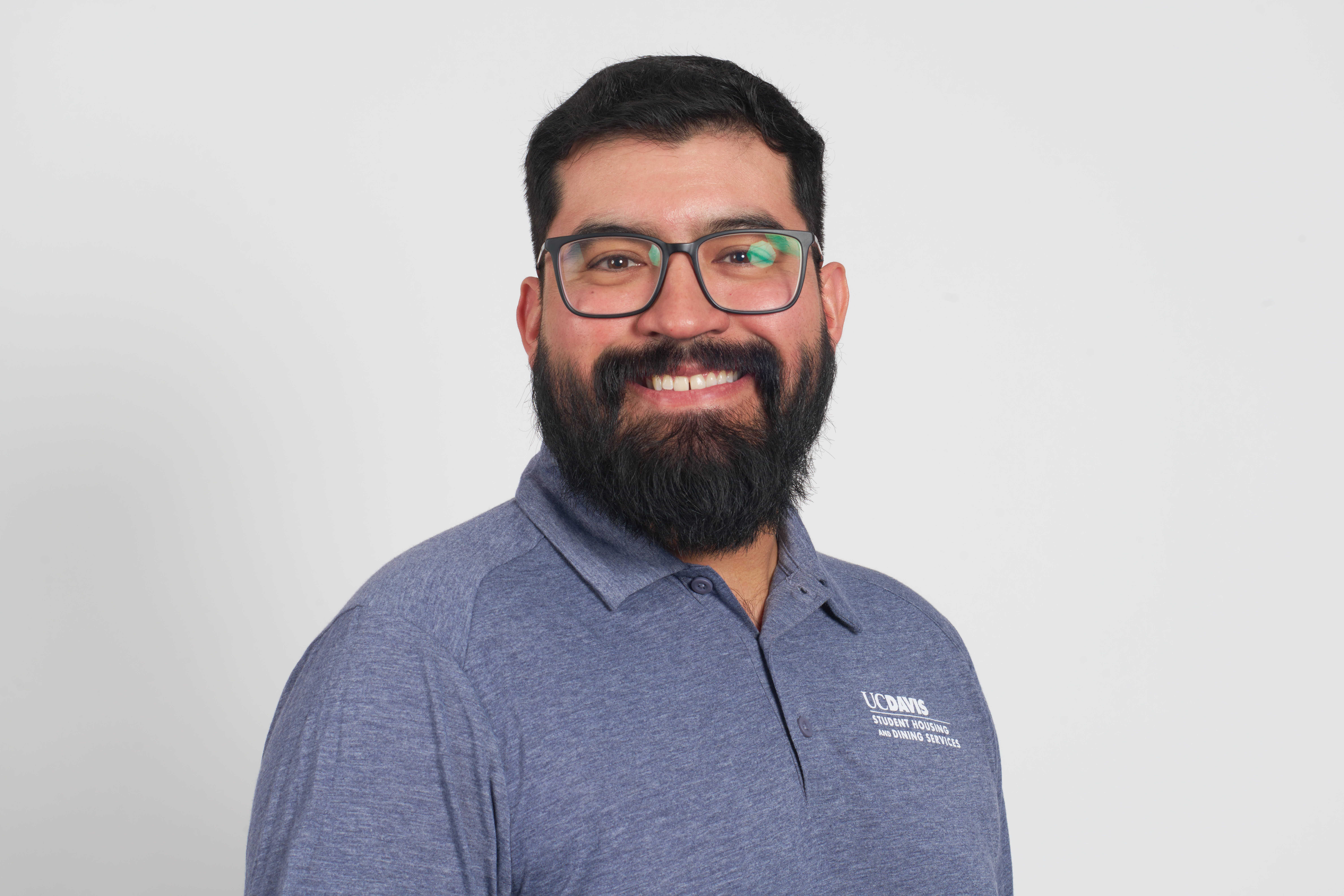 A portrait of a man wearing glasses smiling at the camera