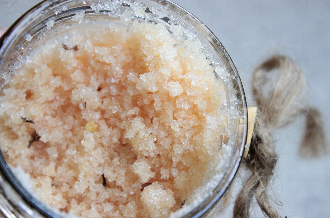 Close up of a jar with body scrub made from sugar and natural oils