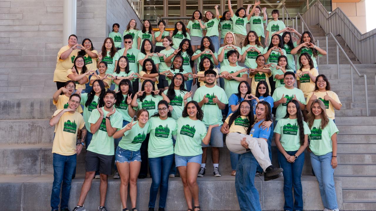First Year Experience Staff stands in the Teaching & Learning Complex Stairway.