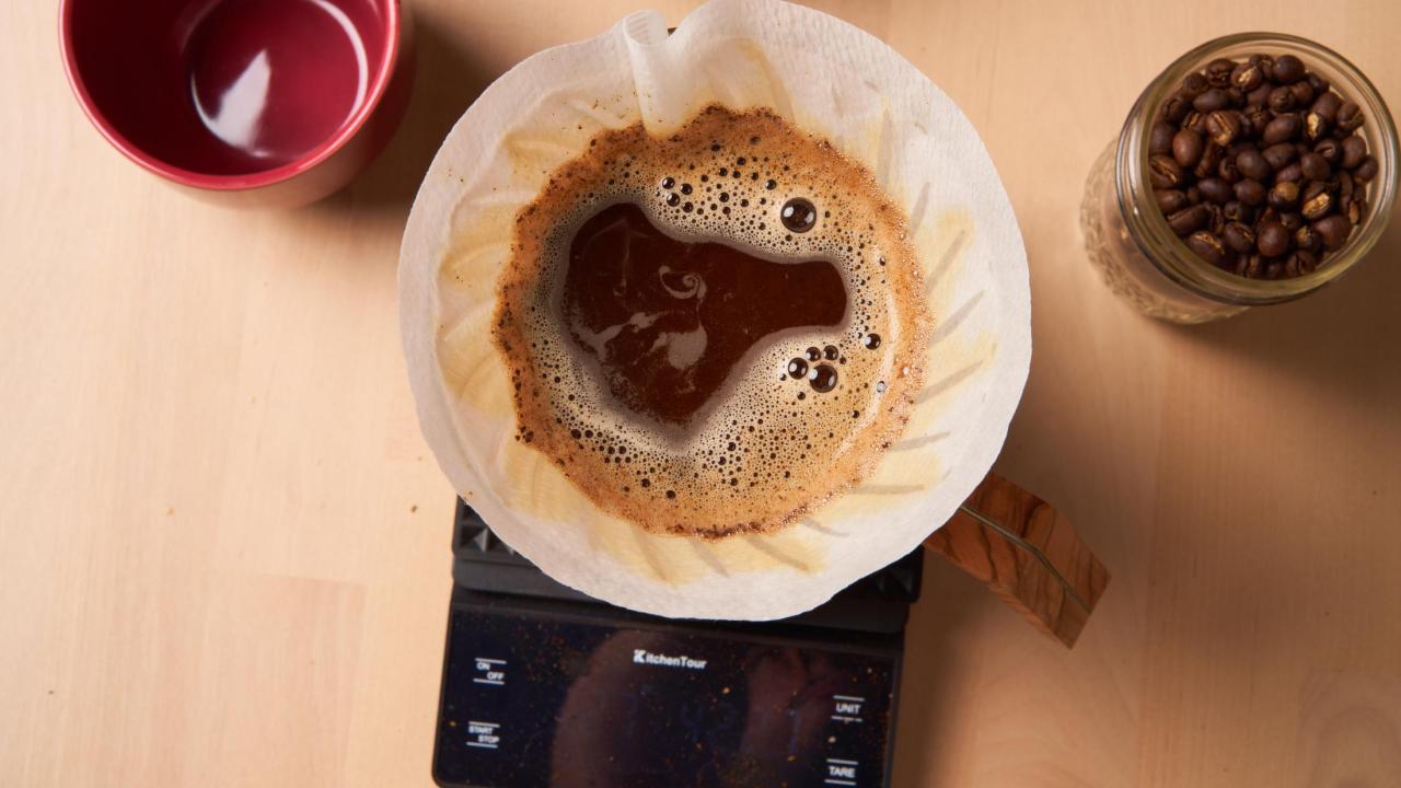Image of a pour over coffee, a mug, and coffee beans.