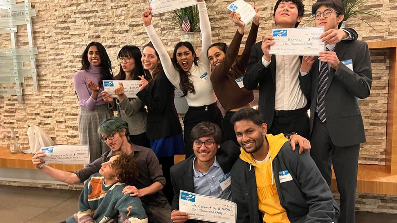 group of students excitedly holding prize checks from Little Bang Pitch Competition