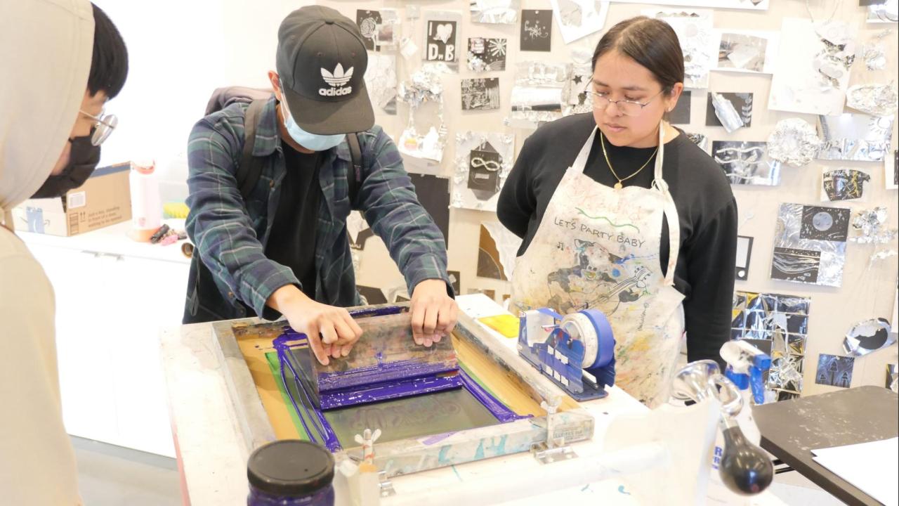Two people creating a screen print