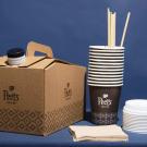 Joe To-go order including coffe in to-go container, compostable cups, lids, napkins, and stir sticks