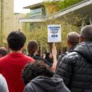 Housing tour group from behind.  Tour guide holding up a sign that reads "Housing Tours Currant Room #408"